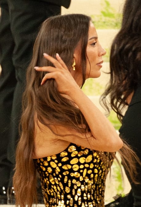 Mira Murati photographed in profile at the 2026 Met Gala, hair swept back, wearing a gold sequined gown